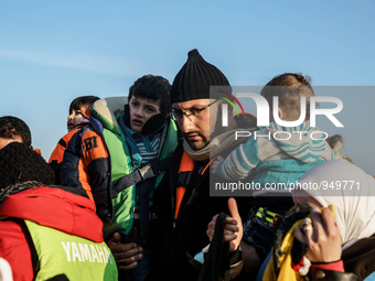 Refugees and migrants aboard a dinghy approach the northeastern Greek island of Lesbos after traveling from the Turkish coast  Dec. 8, 2015....