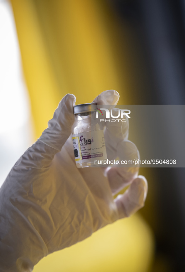 An Iranian female health personnel holds a vial of Noora, Iranian new coronavirus disease (COVID-19) vaccine, at a mobile vaccination statio...