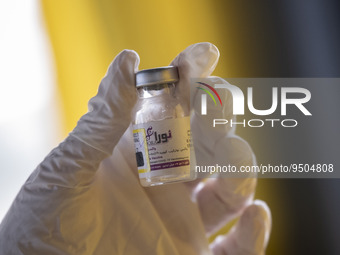 An Iranian female health personnel holds a vial of Noora, Iranian new coronavirus disease (COVID-19) vaccine, at a mobile vaccination statio...