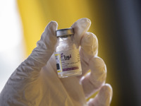 An Iranian female health personnel holds a vial of Noora, Iranian new coronavirus disease (COVID-19) vaccine, at a mobile vaccination statio...