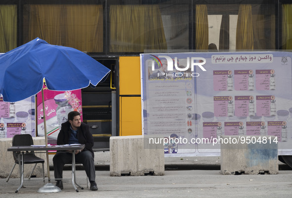 A staff member of the Baqiyatallah hospital sits in front of a new coronavirus disease (COVID-19) mobile vaccination station during Tehran's...