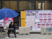 A staff member of the Baqiyatallah hospital sits in front of a new coronavirus disease (COVID-19) mobile vaccination station during Tehran's...