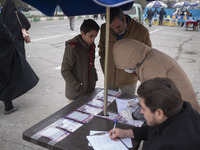 An Iranian worshipper and his son register to receive a dose of the Iranian Noora new coronavirus disease (COVID-19) vaccine out of a COVID-...