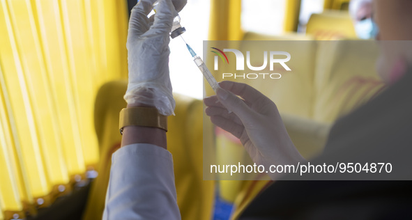 An Iranian female health personnel wearing a protective face mask loads a syringe with the Iranian Noora new coronavirus disease (COVID-19)...