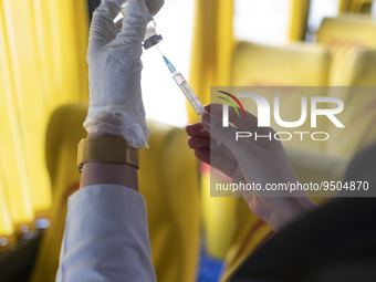 An Iranian female health personnel wearing a protective face mask loads a syringe with the Iranian Noora new coronavirus disease (COVID-19)...