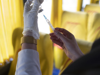 An Iranian female health personnel wearing a protective face mask loads a syringe with the Iranian Noora new coronavirus disease (COVID-19)...