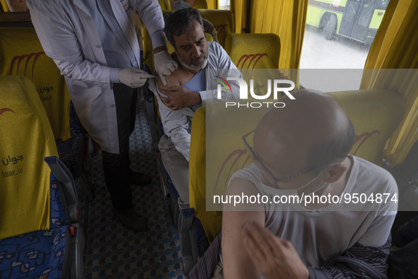 An Iranian worshipper receives a dose of the Iranian Noora new coronavirus disease (COVID-19) vaccine at a mobile vaccination station during...