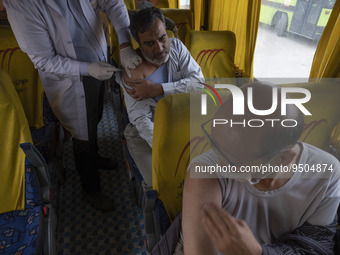 An Iranian worshipper receives a dose of the Iranian Noora new coronavirus disease (COVID-19) vaccine at a mobile vaccination station during...