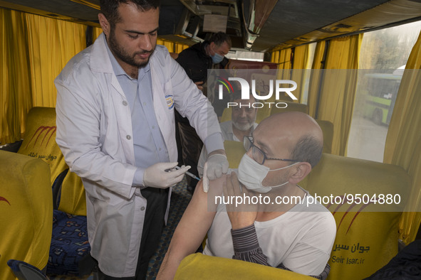 An Iranian worshipper wearing a protective face mask receives a dose of the Iranian Noora new coronavirus disease (COVID-19) vaccine at a mo...