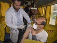 An Iranian worshipper wearing a protective face mask receives a dose of the Iranian Noora new coronavirus disease (COVID-19) vaccine at a mo...