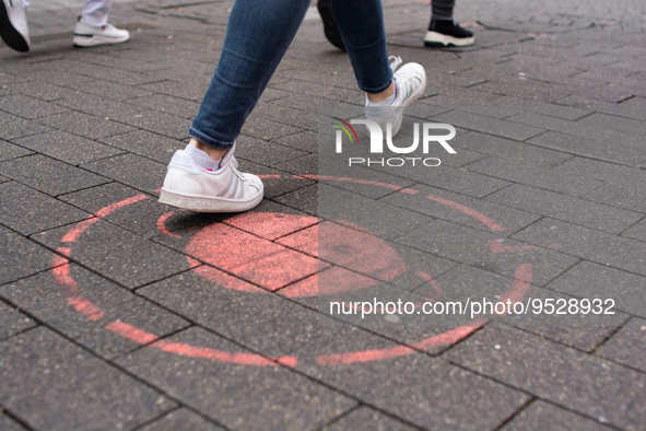 

A faded mask sign is seen on the pavement of the shopping area of the city center in Cologne, Germany, on February 1, 2023, as the state g...