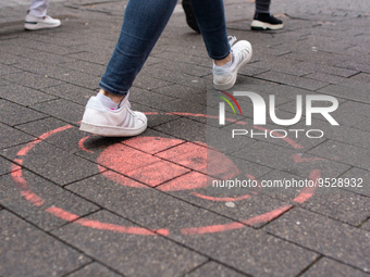 

A faded mask sign is seen on the pavement of the shopping area of the city center in Cologne, Germany, on February 1, 2023, as the state g...