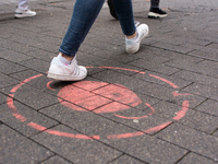 

A faded mask sign is seen on the pavement of the shopping area of the city center in Cologne, Germany, on February 1, 2023, as the state g...