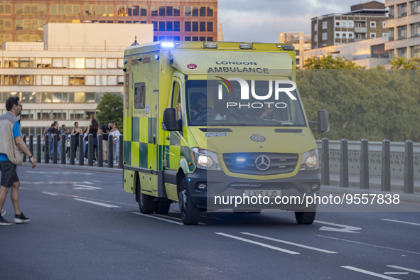 Yellow ambulance spotted on Westminster Bridge, an emergency service vehicle with paramedics of the National Health Service NHS in motion on...