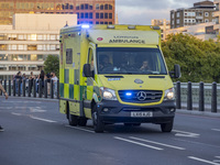 Yellow ambulance spotted on Westminster Bridge, an emergency service vehicle with paramedics of the National Health Service NHS in motion on...