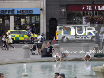 Yellow ambulance, an emergency service vehicle with paramedics of the National Health Service NHS parked behind a police car on the streets...