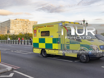 Yellow ambulance spotted on Westminster Bridge, an emergency service vehicle with paramedics of the National Health Service NHS in motion on...