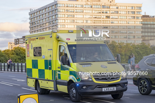 Yellow ambulance spotted on Westminster Bridge, an emergency service vehicle with paramedics of the National Health Service NHS in motion on...