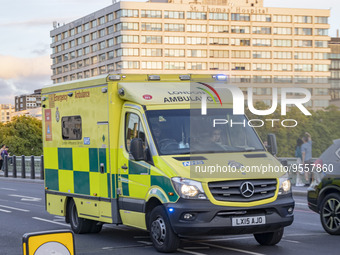 Yellow ambulance spotted on Westminster Bridge, an emergency service vehicle with paramedics of the National Health Service NHS in motion on...