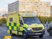 Yellow ambulance spotted on Westminster Bridge, an emergency service vehicle with paramedics of the National Health Service NHS in motion on...