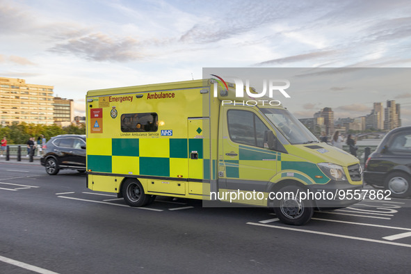 Yellow ambulance spotted on Westminster Bridge, an emergency service vehicle with paramedics of the National Health Service NHS in motion on...