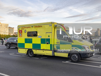 Yellow ambulance spotted on Westminster Bridge, an emergency service vehicle with paramedics of the National Health Service NHS in motion on...