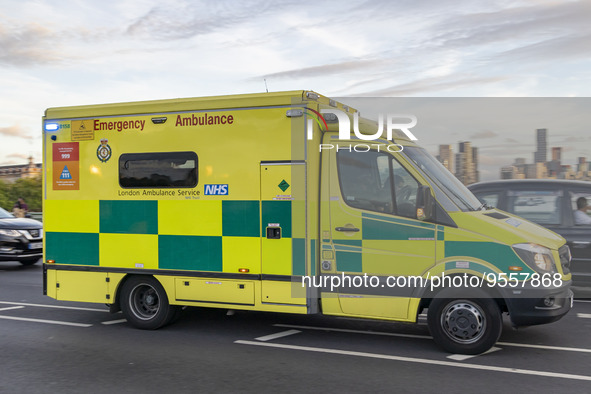 Yellow ambulance spotted on Westminster Bridge, an emergency service vehicle with paramedics of the National Health Service NHS in motion on...