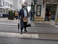 A woman wearing protective mask is seen walking along one of the streets in the Baixa district. Lisbon, January 23, 2023. In Portugal, the t...