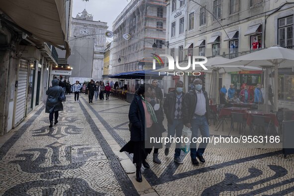 People using protective mask are seen walking along one of the streets in the Baixa district. Lisbon, January 23, 2023. In Portugal, the tra...