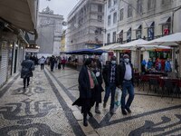 People using protective mask are seen walking along one of the streets in the Baixa district. Lisbon, January 23, 2023. In Portugal, the tra...