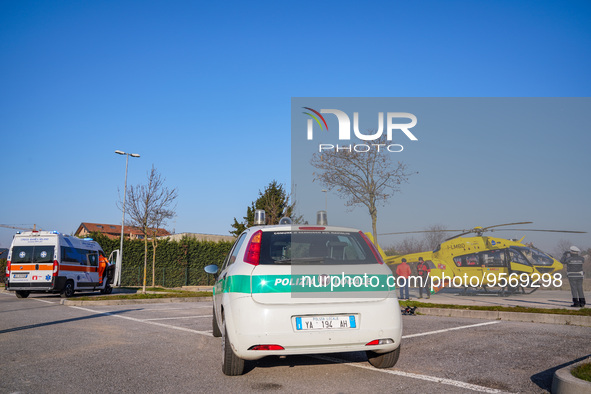 Police car and Medical helicopter landed in the background in a public car parking , in Cernusco sul Naviglio, Italy, on February 10, 2023....