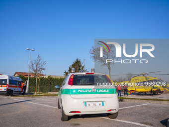 Police car and Medical helicopter landed in the background in a public car parking , in Cernusco sul Naviglio, Italy, on February 10, 2023....