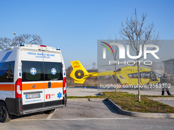 Ambulance and Medical helicopter landed in the background in a public car parking , in Cernusco sul Naviglio, Italy, on February 10, 2023....