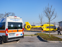 Ambulance and Medical helicopter landed in the background in a public car parking , in Cernusco sul Naviglio, Italy, on February 10, 2023....