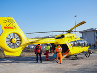 Injured person on the stretcher enters in the Medical helicopter landed in a public car parking , in Cernusco sul Naviglio, Italy, on Februa...