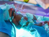 A nurse is taking care of one of the quintuplets laying in an incubator. Krakow, Poland on February 14, 2023. Three girls and two boys were...