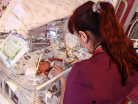 A nurse is taking care of one of the quintuplets laying in an incubator. Krakow, Poland on February 14, 2023. Three girls and two boys were...