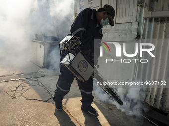 A Thai health officer sprays chemicals to kill mosquitos for the health precaution against dengue fever inside a community in Bangkok, Thail...