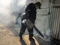 A Thai health officer sprays chemicals to kill mosquitos for the health precaution against dengue fever inside a community in Bangkok, Thail...