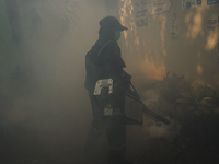 A Thai health officer sprays chemicals to kill mosquitos for the health precaution against dengue fever inside a community in Bangkok, Thail...