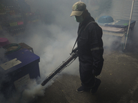 A Thai health officer sprays chemicals to kill mosquitos for the health precaution against dengue fever inside a community in Bangkok, Thail...