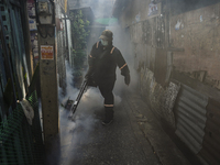 A Thai health officer sprays chemicals to kill mosquitos for the health precaution against dengue fever inside a community in Bangkok, Thail...