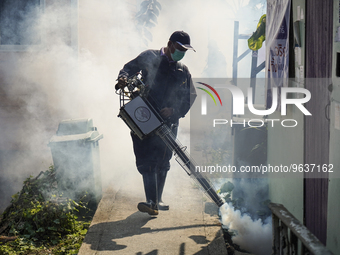 A Thai health officer sprays chemicals to kill mosquitos for the health precaution against dengue fever inside a community in Bangkok, Thail...