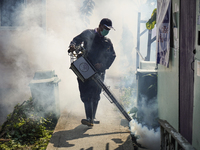 A Thai health officer sprays chemicals to kill mosquitos for the health precaution against dengue fever inside a community in Bangkok, Thail...