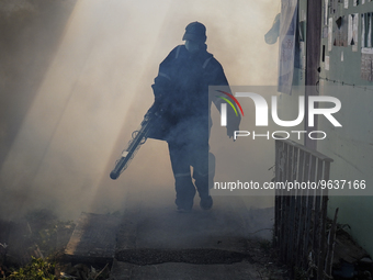 A Thai health officer sprays chemicals to kill mosquitos for the health precaution against dengue fever inside a community in Bangkok, Thail...