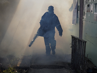 A Thai health officer sprays chemicals to kill mosquitos for the health precaution against dengue fever inside a community in Bangkok, Thail...