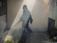 A Thai health officer sprays chemicals to kill mosquitos for the health precaution against dengue fever inside a community in Bangkok, Thail...