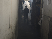 A Thai health officer sprays chemicals to kill mosquitos for the health precaution against dengue fever inside a community in Bangkok, Thail...