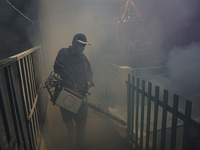 A Thai health officer sprays chemicals to kill mosquitos for the health precaution against dengue fever inside a community in Bangkok, Thail...