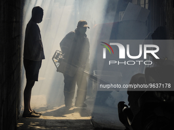 A Thai health officer sprays chemicals to kill mosquitos for the health precaution against dengue fever inside a community in Bangkok, Thail...